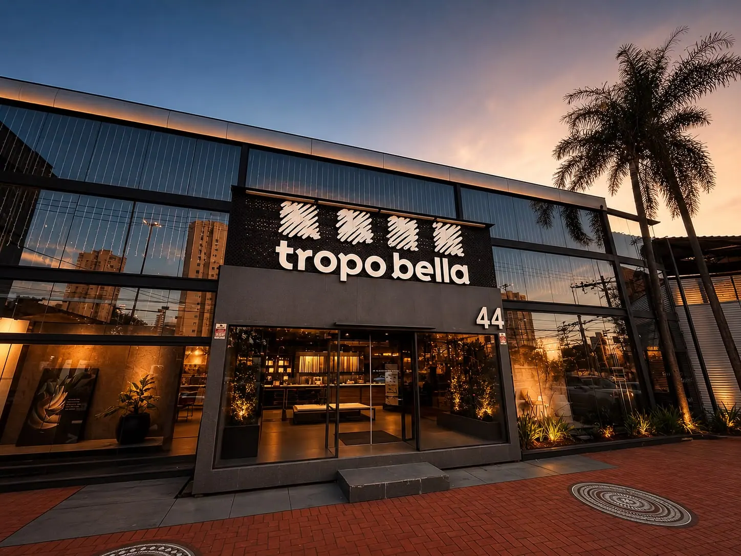 Fachada do showroom da Tropobella no Tatuapé, em São Paulo, ao entardecer, com o letreiro iluminado